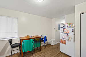Dining space featuring wood finished floors and a textured ceiling