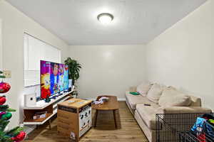 Living room with a textured ceiling and wood finished floors