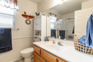 Bathroom with vanity, a stall shower, and healthy amount of natural light