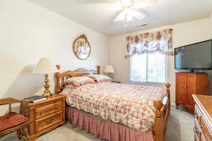 Bedroom with light colored carpet and ceiling fan