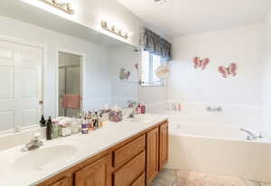 Bathroom with double vanity, a garden tub, a shower stall, and light tile patterned floors