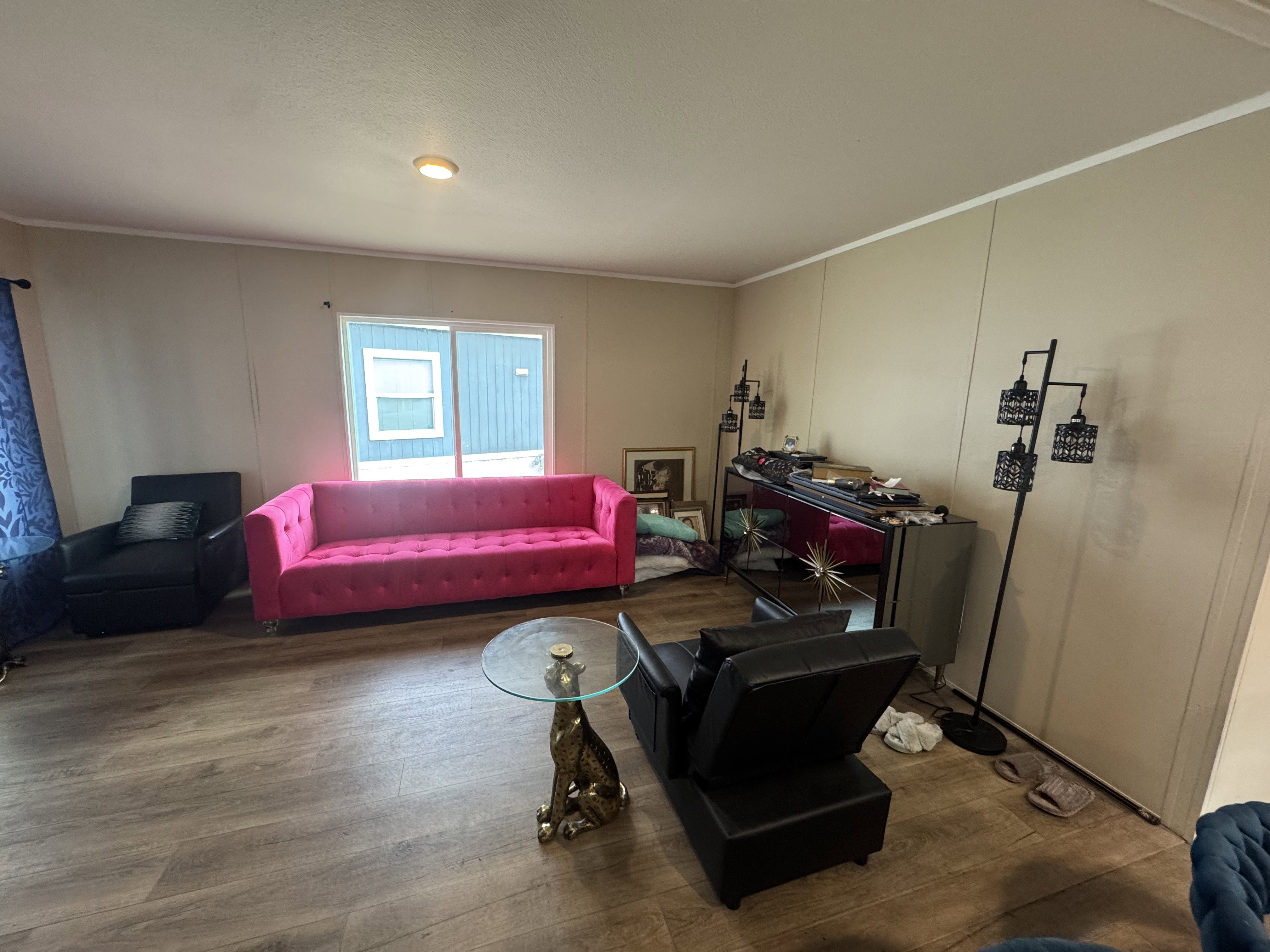 Living room with a decorative wall, wood finished floors, and ornamental molding
