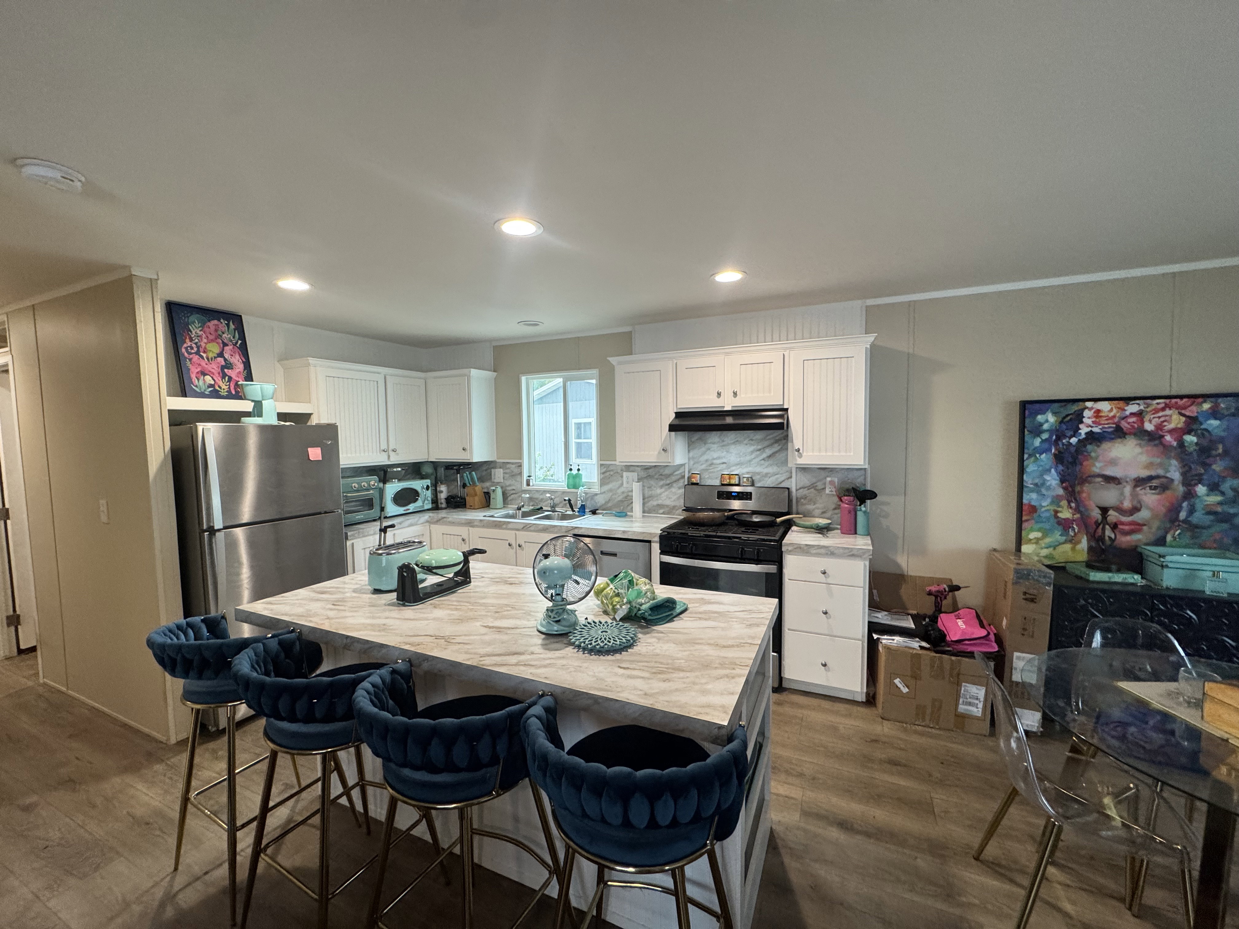 Kitchen with white cabinetry, dark wood-style flooring, a kitchen island, ornamental molding, and recessed lighting