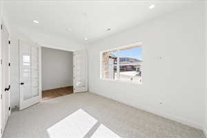 Unfurnished bedroom with french doors, carpet, and recessed lighting