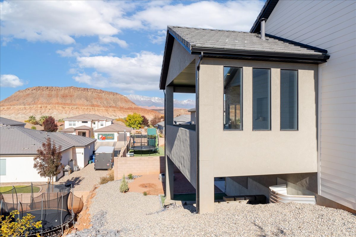 View of property exterior with a trampoline, a mountain view, and a residential view