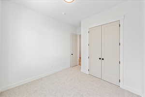 Unfurnished bedroom with a closet and carpet flooring