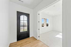 Foyer with light wood-style flooring and baseboards