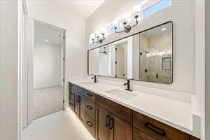 Full bathroom with double vanity, a shower stall, and recessed lighting