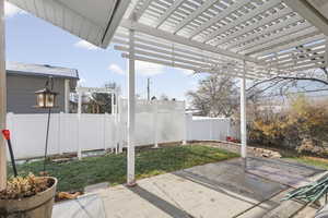 Fenced backyard with a pergola and a patio area