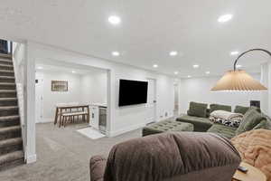 Living area with stairway, light colored carpet, wine cooler, and recessed lighting