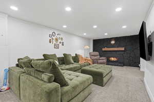Home theater with carpet flooring, a fireplace, and recessed lighting