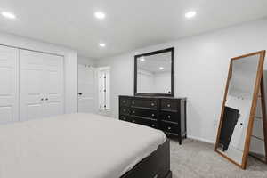Bedroom featuring light carpet, a closet, and recessed lighting