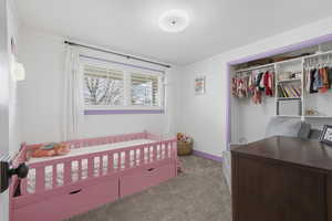 Carpeted bedroom featuring a closet and ornamental molding