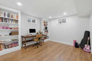 Office space with light wood-style flooring, built in shelves, and recessed lighting