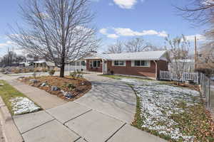 Single story home featuring brick siding and concrete driveway
