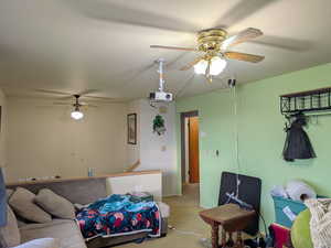Carpeted living room featuring a ceiling fan