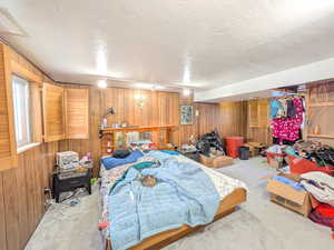 Carpeted bedroom with wood walls
