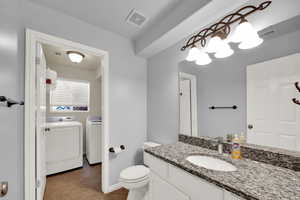 Full bathroom with vanity, light tile patterned flooring, and separate washer and dryer