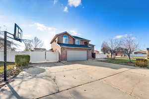 View of front of house featuring brick siding, concrete driveway, and a garage