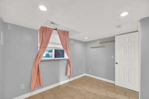 Empty room with recessed lighting and light tile patterned floors