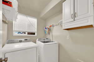 Laundry room with cabinet space and washer and clothes dryer
