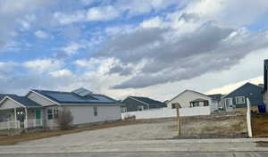 View of front facade with roof mounted solar panels, a residential view, and a porch