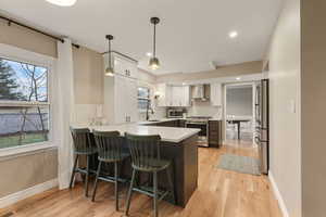 Kitchen also includes bar seating, new windows, and handmade pendant lights.