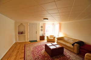 Living room with light wood-type flooring and crown molding