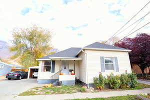 Bungalow-style home with roof with shingles and a porch