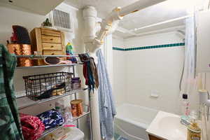 Bathroom with vanity and shower / tub combo with curtain