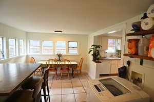 Dining room with light tile patterned floors and washer and dryer