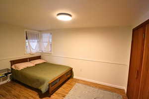 Bedroom featuring light wood finished floors and baseboards