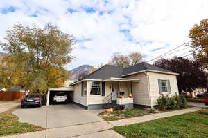 View of front of house with a porch, driveway, a mountain view, and a shingled roof
