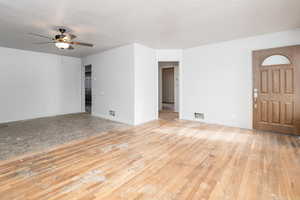 Unfurnished living room with light wood finished floors and a ceiling fan