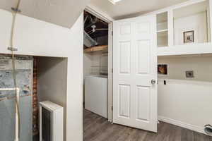 Laundry area with dark wood-style floors, hookup for a washing machine, and hookup for an electric dryer
