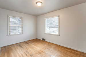 Spare room featuring light wood-type flooring and plenty of natural light