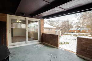 Snow covered patio featuring a patio and a shed