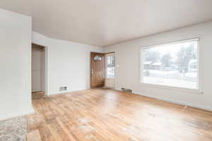 Unfurnished living room with light wood finished floors and baseboards