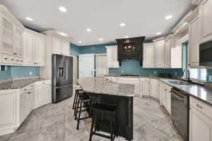 Kitchen featuring light stone counters, stainless steel appliances, glass insert cabinets, recessed lighting, and a breakfast bar