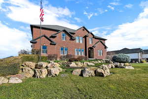 Traditional-style house with brick siding and a front yard