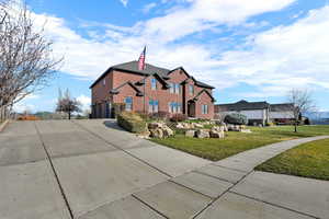 Traditional-style home featuring concrete driveway, a front lawn, a garage, and brick siding