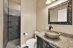 Full bath with a tile shower and vanity