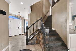 Foyer entrance featuring recessed lighting, a chandelier, and stairway
