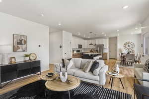 Living room with light wood finished floors and recessed lighting