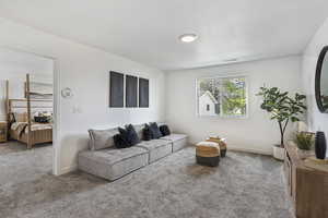 Carpeted living area featuring a textured ceiling and baseboards