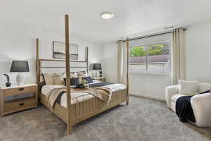 Carpeted bedroom with a textured ceiling and baseboards