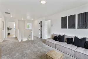 Carpeted living area with recessed lighting and baseboards