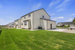 Back of house featuring a lawn, stucco siding, and a residential view