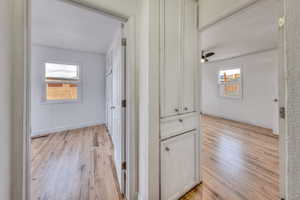 Hall featuring hardwood floors and healthy amount of natural light