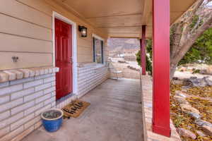 Property entrance featuring a porch and brick siding